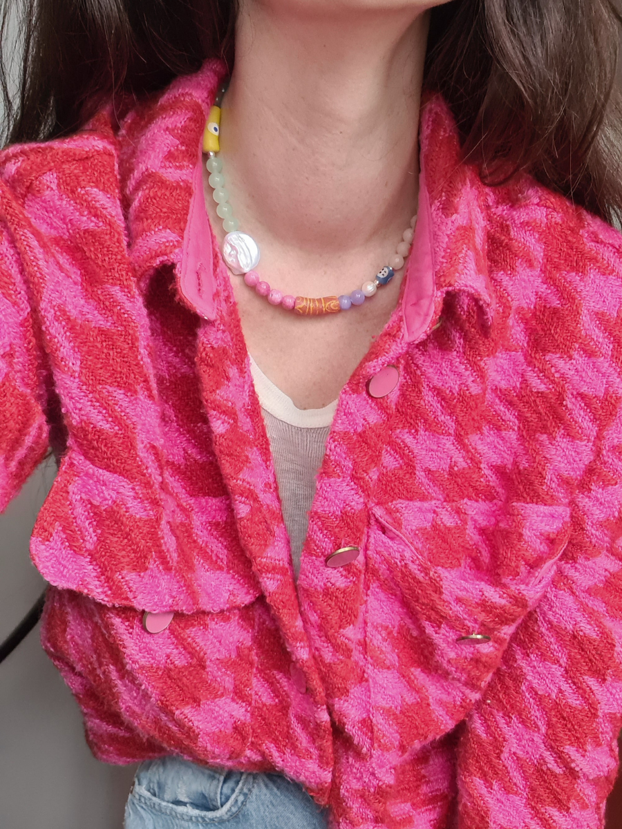 Model trägt pastellfarbene Kette aus bunt gefärbten Jadeperlen mit großer Süßwasserperle und pink, kariertem Shirt